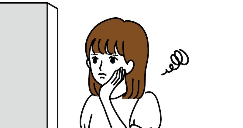 鏡を見て悩む女性